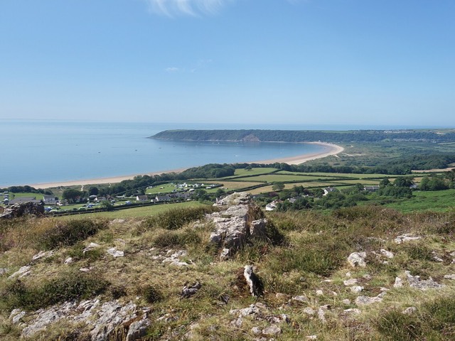 خليج أوكسويش (Oxwich Bay) على ساحل غاور في ويلز، من مسار على رأس بحري، وخلفه شاطئ رملي طويل